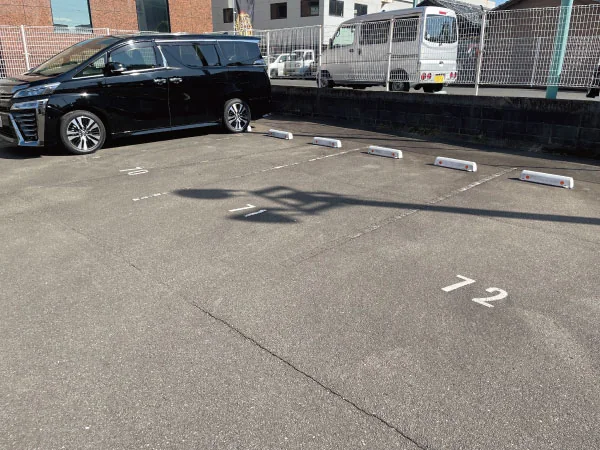 江平ビルの駐車場。路面に71番・72番などの番号が表示されている